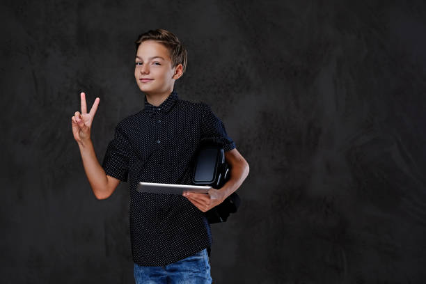 Student with a tablet and VR headset making a peace sign