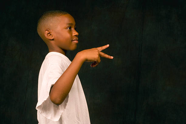 Student in a white shirt making a peace sign, profile view